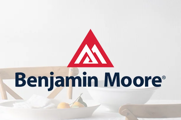 Benjamin Moore logo with a lifestyle of a dining room setup in the background