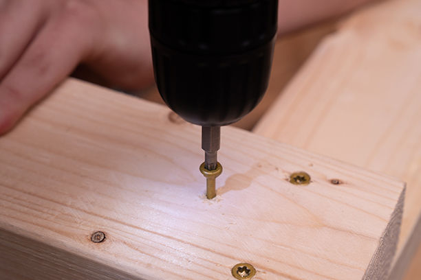 Close-up drilling screws into wood