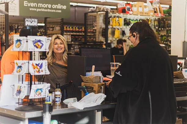 A man and a woman both looking at a touchscreen device discussing pricing