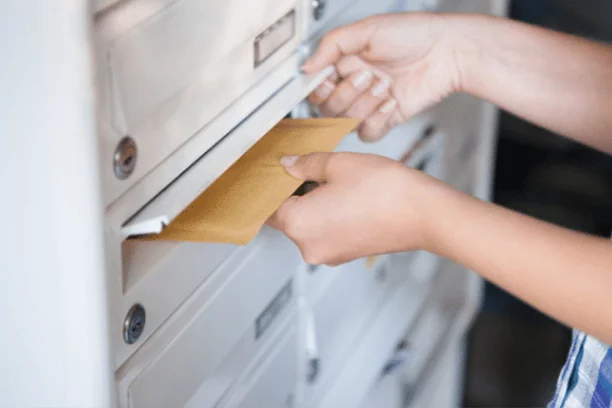 Envelope Being Dropped off in Mailbox