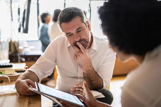 A man sitting down with a woman discussing ideas and options