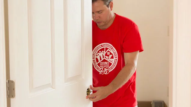 Valu volunteer installing a door knob