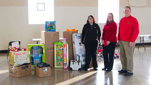 Valu crew standing next to toys being donated to YWCA