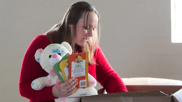 Valu team member putting toys in a box