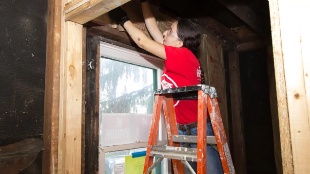 Valu Crew volunteer putting in insulation above window