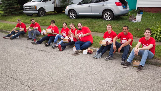 Valu Crew sitting on the side of the curb having lunch