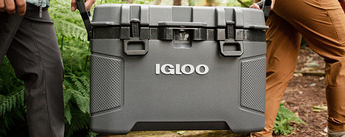 Lifestyle image of two people carrying an Igloo hard-sided cooler from the waist down with the Igloo logo on the left side of the banner