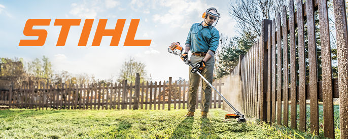 Stihl - Middle aged man using a STIHL gas powered trimmer to clear around a fence