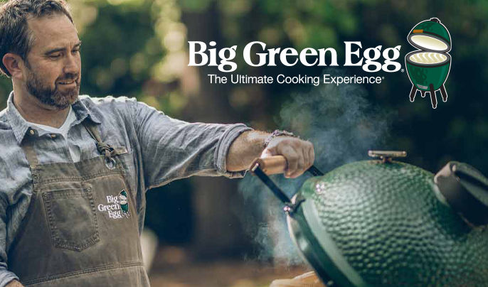 A middle aged man cooking on a Big Green Egg grill.