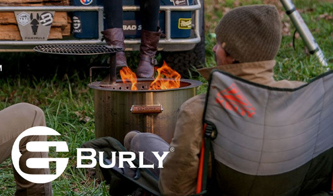 Burly Grills. Three people sitting around a fire pit while camping