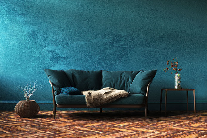 Textured teal/blue wallpaper behind a dark teal couch