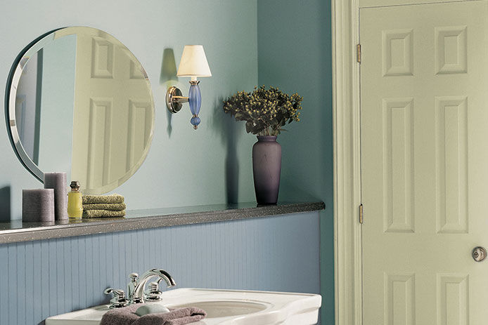A family bathroom with blue walls, porcelain sink and decorative accents on the wall