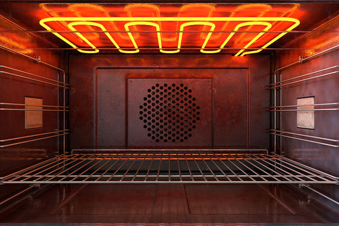 The inside of an oven with the coils glowing red