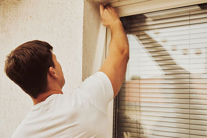 Applying weatherstripping to an outside window 