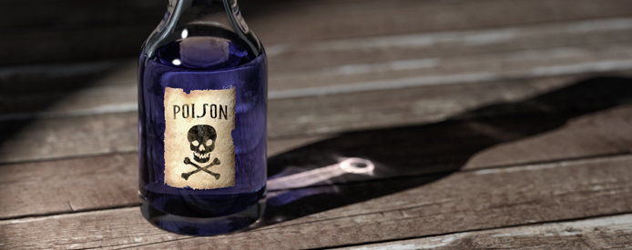 A glass bottle of purple poison on a wooden table