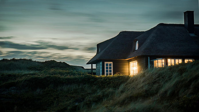 House that is dark on the outside with the inside lights shining