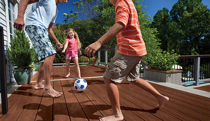 A family playing soccer on a wooden deck