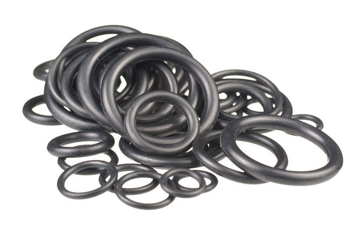 A pile of black O-rings is grouped together. The black rubber rings are in various sizes and thicknesses against a white background.