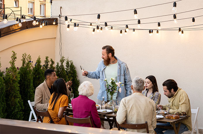 A group of friends together out to have lunch with patio light strung above them