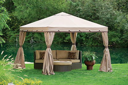 A canvas covered pergola sitting in the middle of a grassy field with a two piece patio set underneith