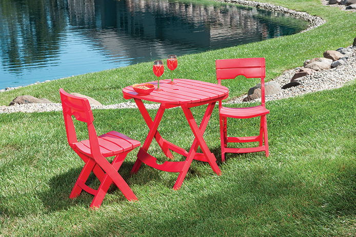 A three piece red resin set sitting on a grassy lawn 