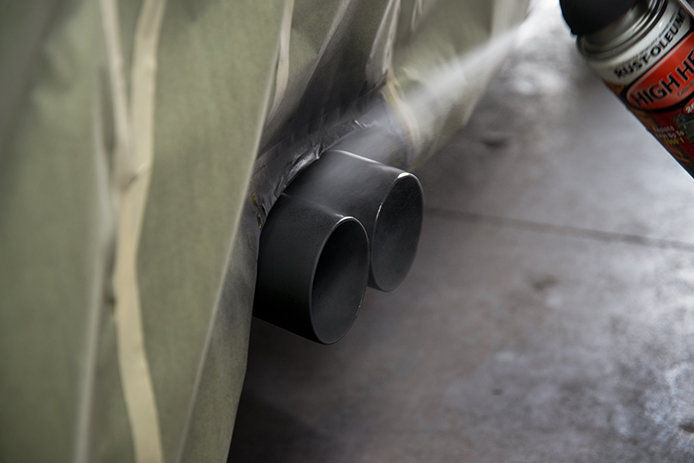 Spray painting the exhaust on a vehicle