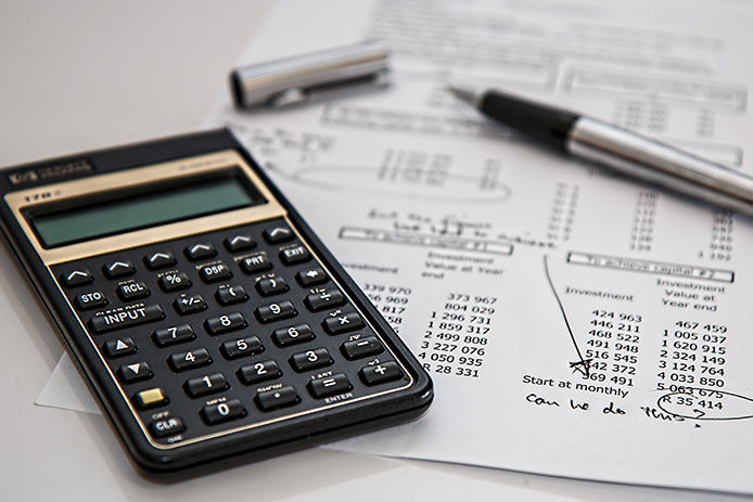 A calculator and a budget plan laying on a counter