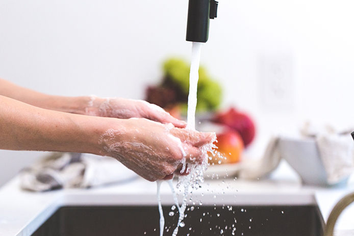 Washing hands in kitchen sink