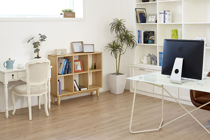 A modern style home office with bright light, white desk, wooden bookshelf and green house plants