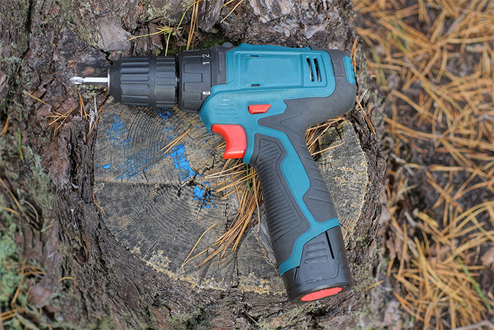 A drill laying on a tree stump