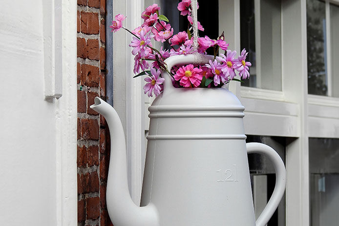Flowers in a watering can hanging from a string