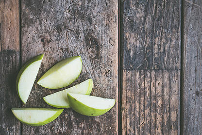 Green apple slices on wooden tabletop