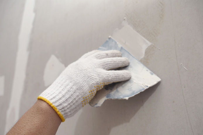 Person patching drywall