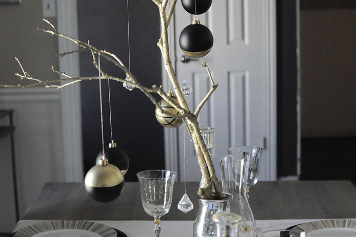 finished painted holiday ornaments hanging from tree on table setting