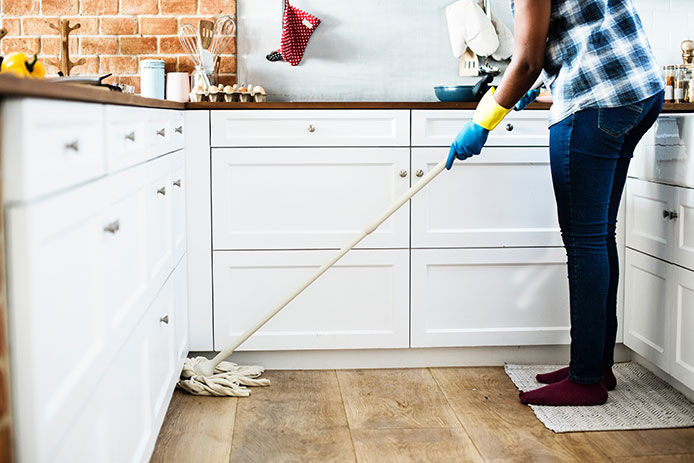 A person mopping a kitchen floor
