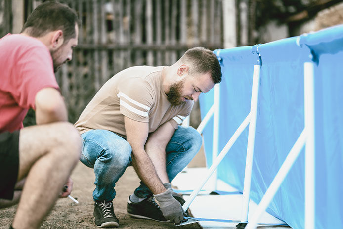 Two men installing an above ground pool