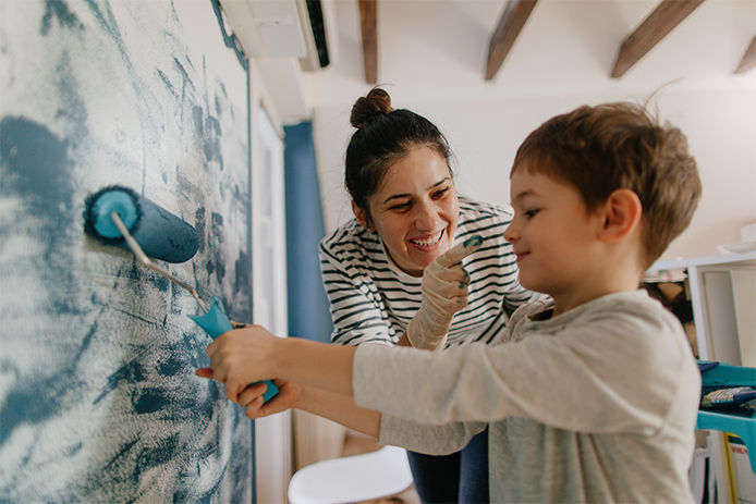 A mother and son painting room walls
