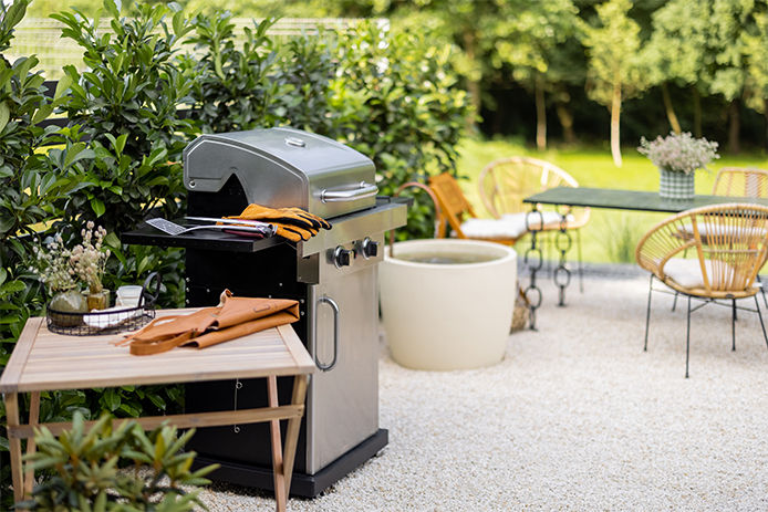 A propane grill on a backyard patio