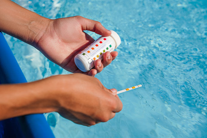 A person testing pool water