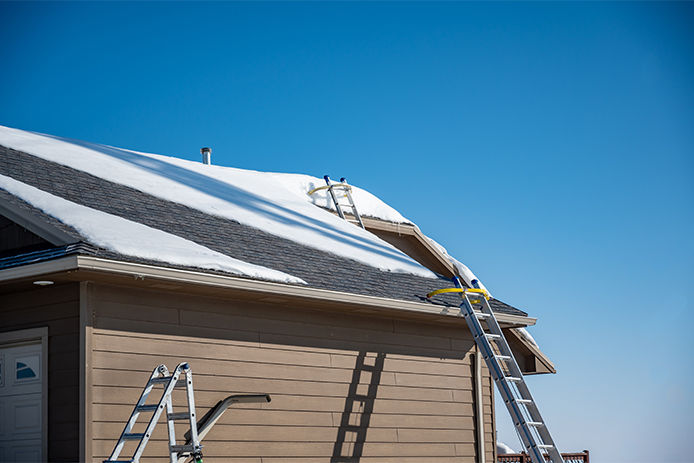 Ladders leaning on a snow covered house