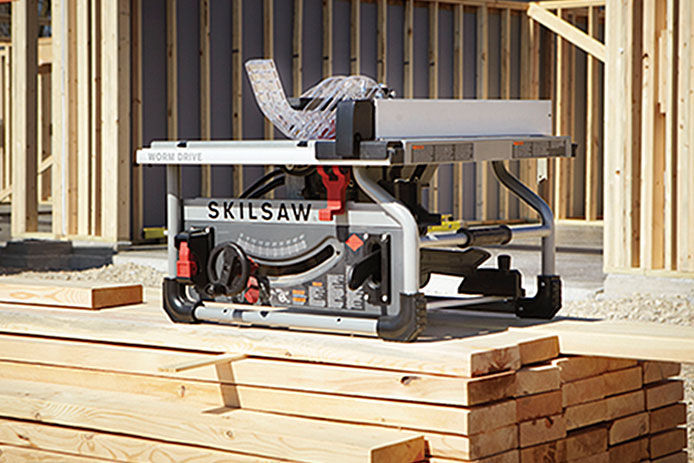 SKILSAW tabletop saw sitting on top of a pile of 2x4 pieces of wood