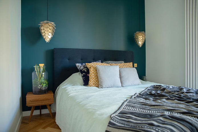 Small, stylish bedroom with blue-green accent wall