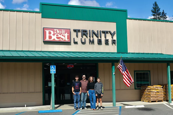 Trinity Lumber owners and family outside storefront