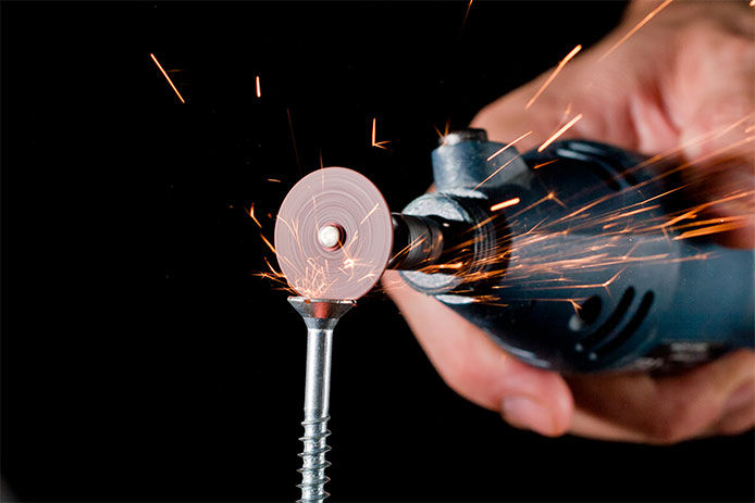 Using a rotary tool to grind a small slot into the head of teh screw