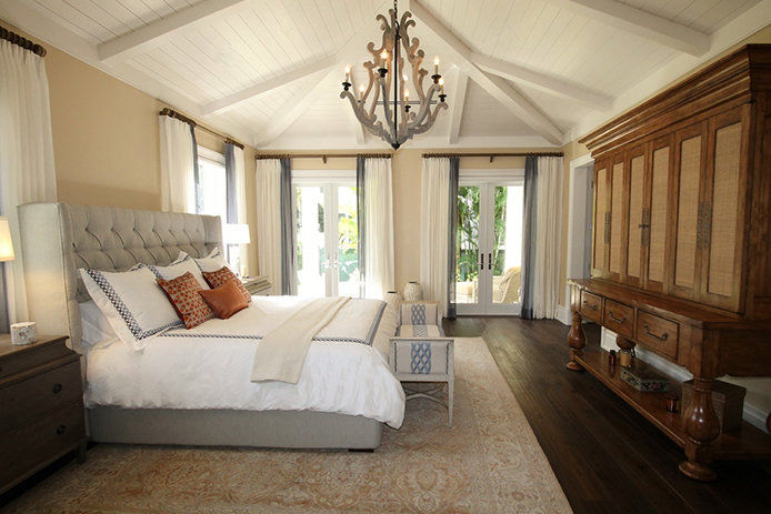 A bedroom with curtians covering large windows