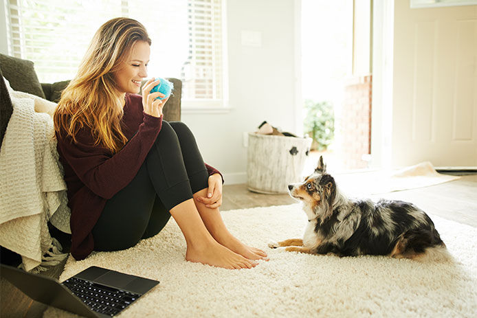 Shot of a young woman spending quality time with her dog at home