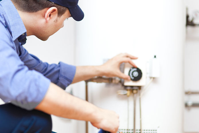 Man adujusting temperature on a water heater