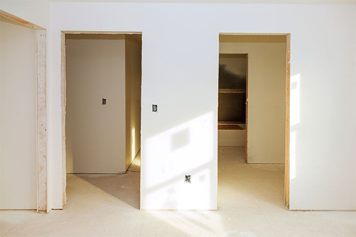 Two door cutouts in a newly constructed home ready to have prehung doors installed 