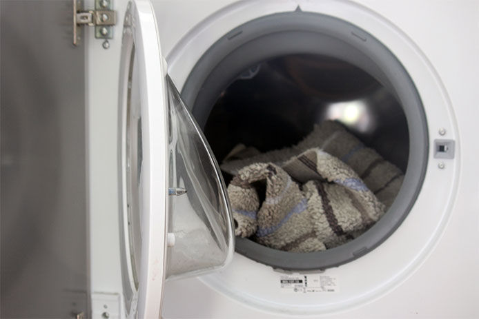 A dryer full of mats and towels