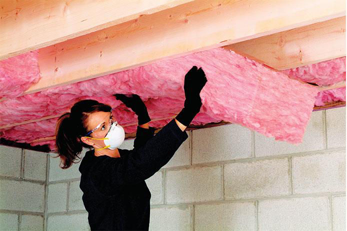 Woman wearing a mask insalling insulation